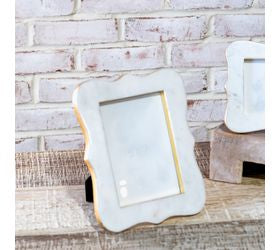 Decorative picture frame with marble-like finish on a wooden surface.
