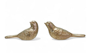 Two antique gold cast iron bird figurines in coordinating poses on a white background