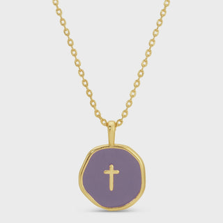 A gold chain necklace with a round, gold-rimmed pendant featuring a lavender purple center and a small gold cross in the middle, shown on a light gray background.