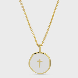 A gold chain necklace with a round, faceted gold pendant featuring a white center and a small gold cross, shown against a light gray background.