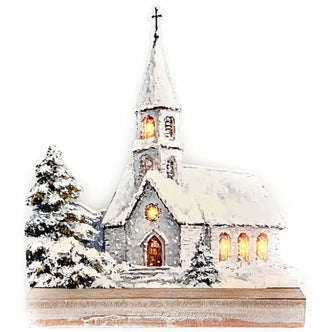 Lighted snowy Christmas church silhouette with glowing windows, a steeple and cross, evergreen tree, and freestanding base on a white background.