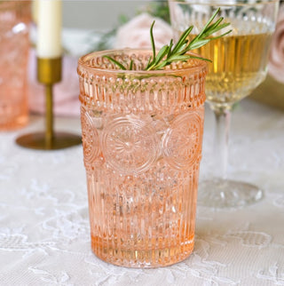 Vintage rose gold textured drinking glass with ornate medallion pattern styled on an elegant table