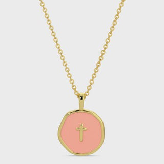 A gold chain necklace with a round gold pendant featuring a soft pink center and a small gold cross in the middle, shown against a light gray background.