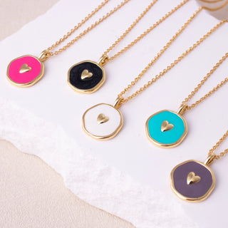 Necklaces with heart-shaped pendants on gold chains against a white background