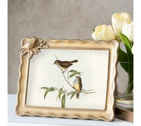 Antique gold 5x7 photo frame with sculpted bird and branch accent displayed beside white tulips
